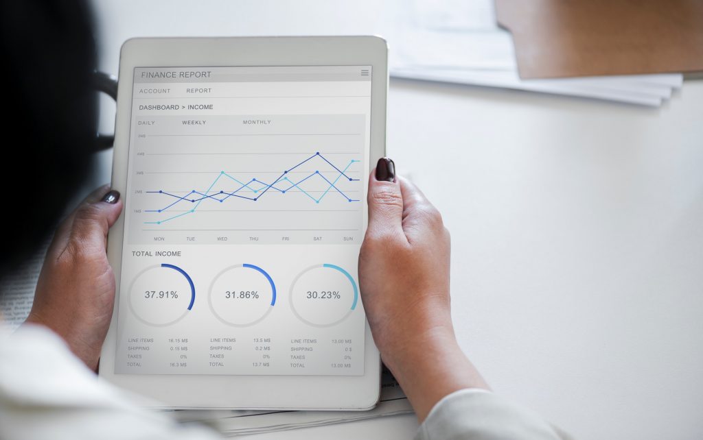 hands holding an ipad with automated data graphed