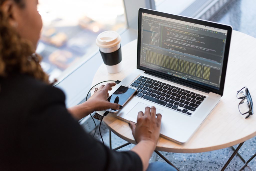 outsourced web developer sitting down and coding on laptop