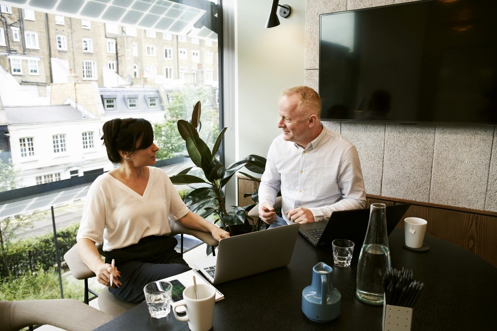 man and woman sitting down and discussing web design questions 