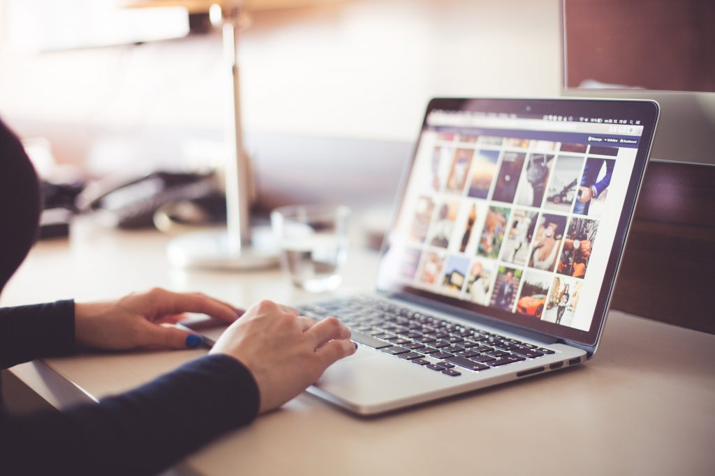 person using laptop to browse for photos