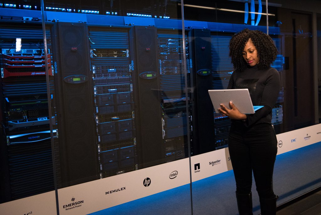 woman holding laptop in front of server for data protection