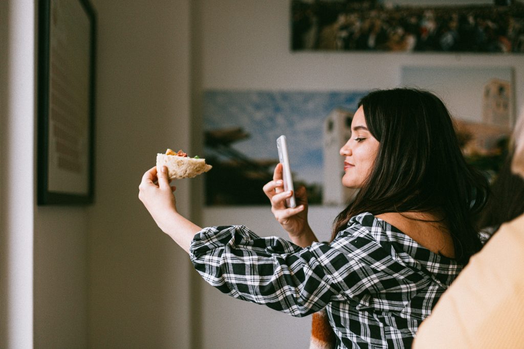 girl taking picture of food for instagram marketing prediction that user generated content is prominent