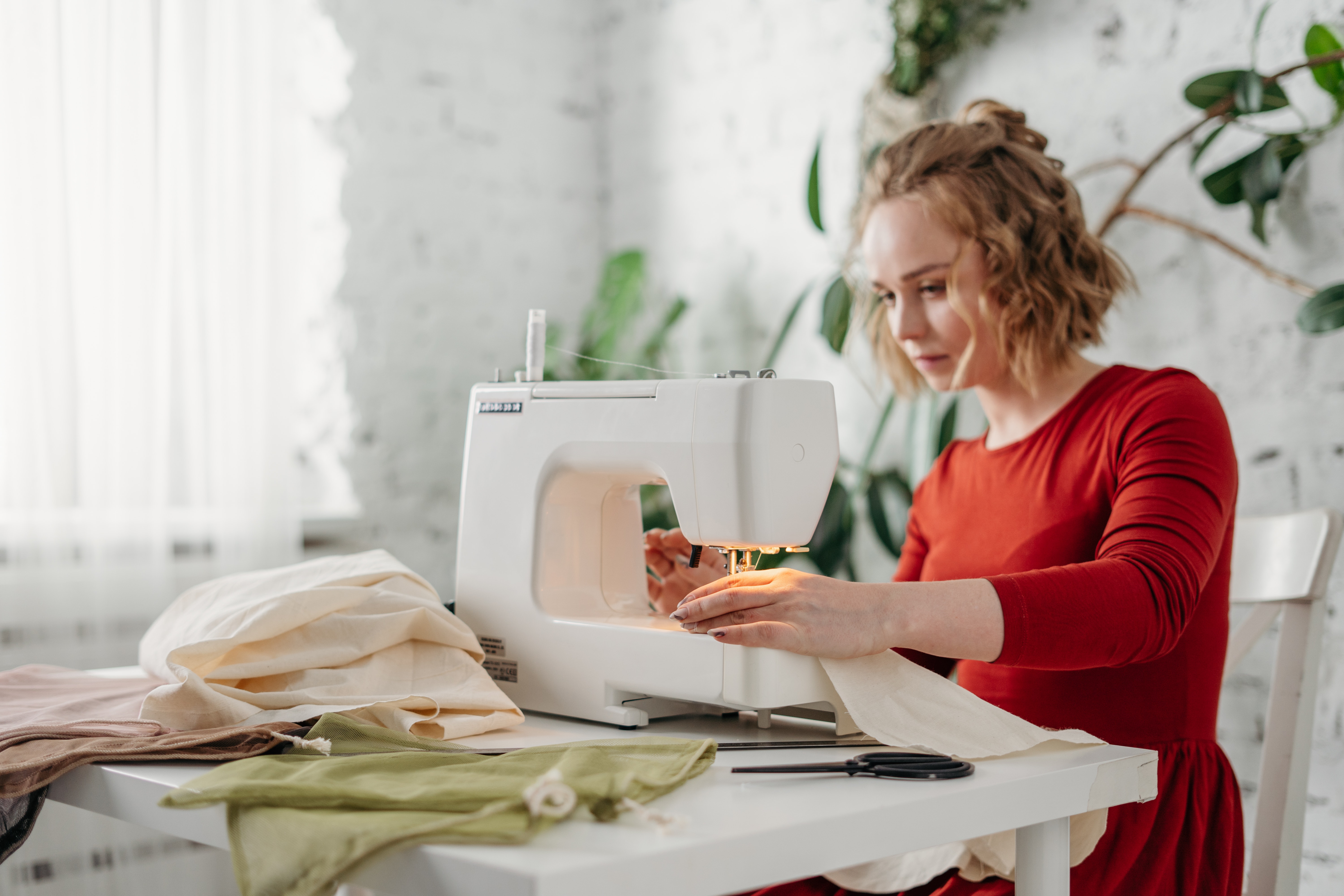 woman sewing handmade products for e-commerce business