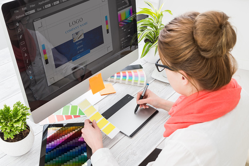 graphic designer using tablet and monitor to work on branding in art station