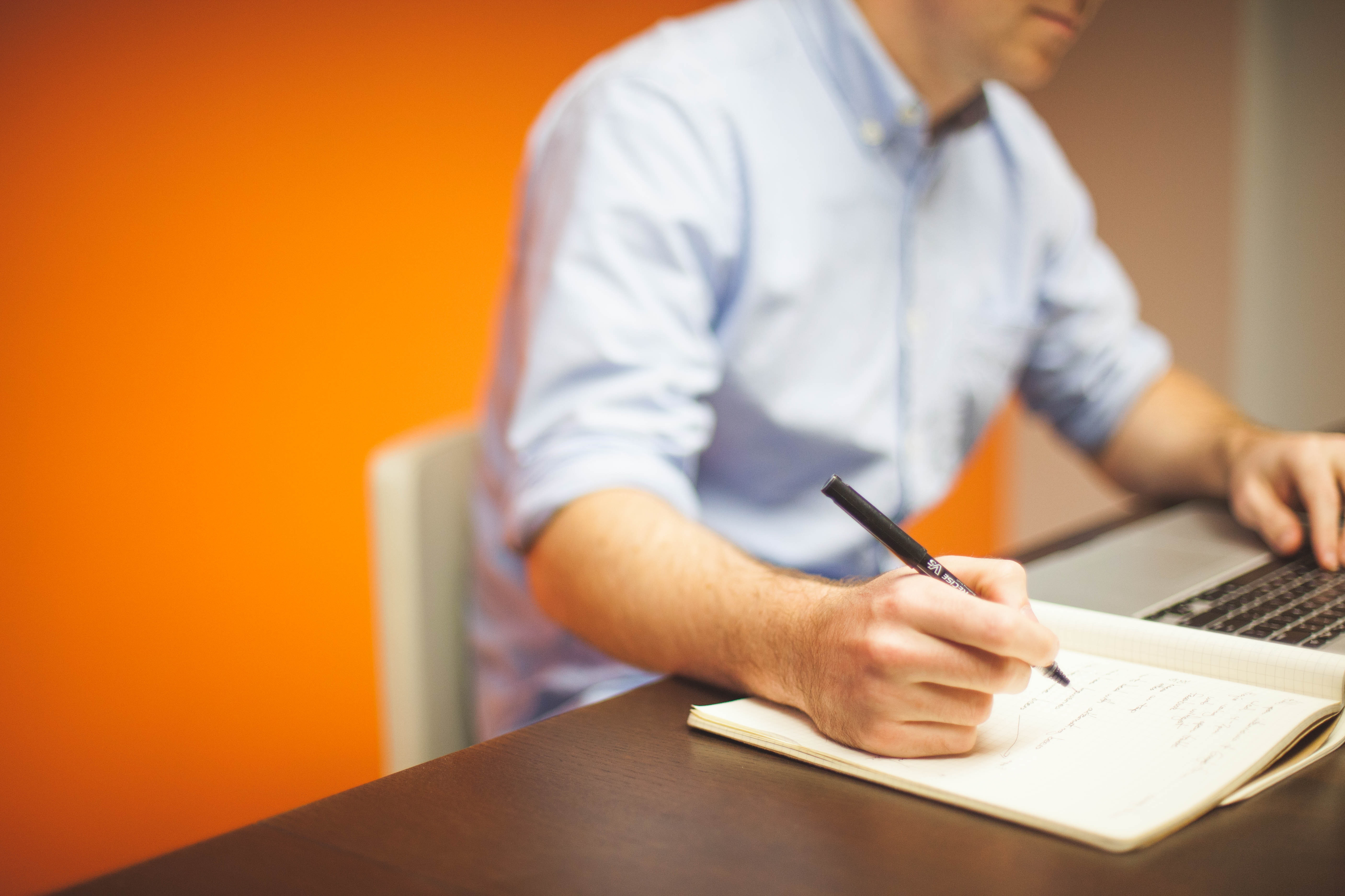 business man writing down details from personalized business email address