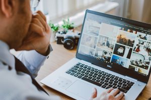 man looking at images on laptop