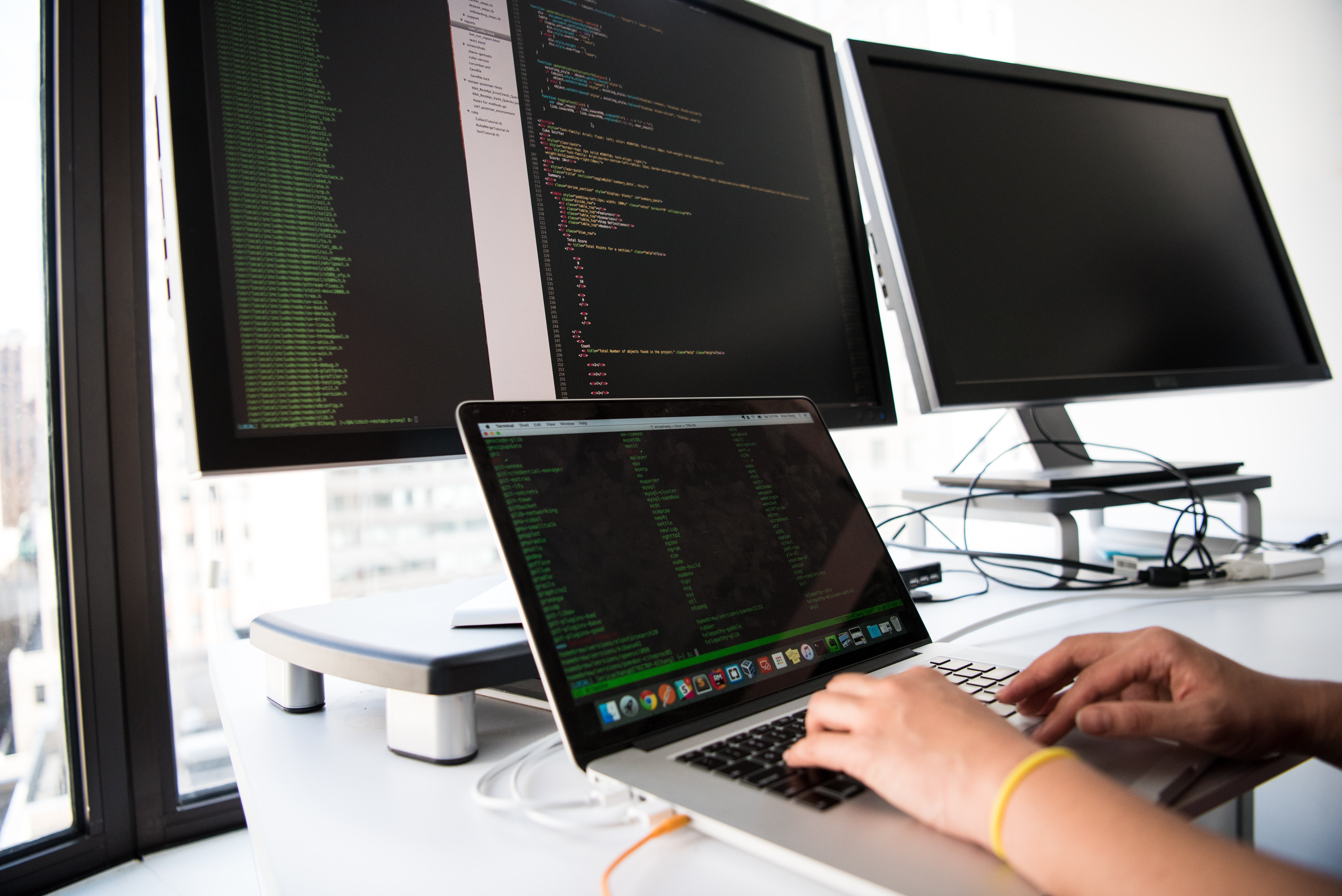 monitors and laptop on table used for improving development skills