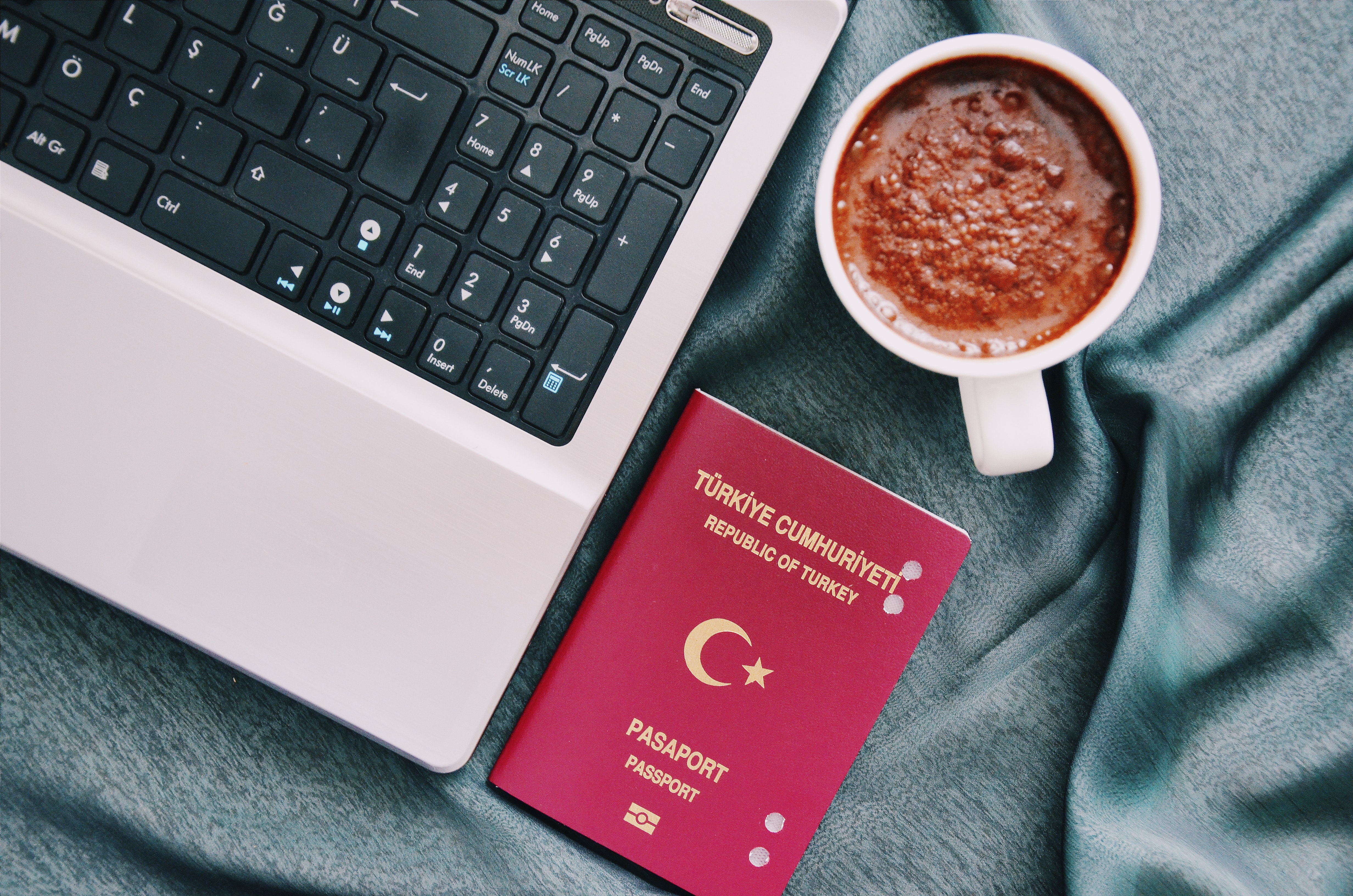 photo of laptop beside cup of coffee and passport from republic of turkey